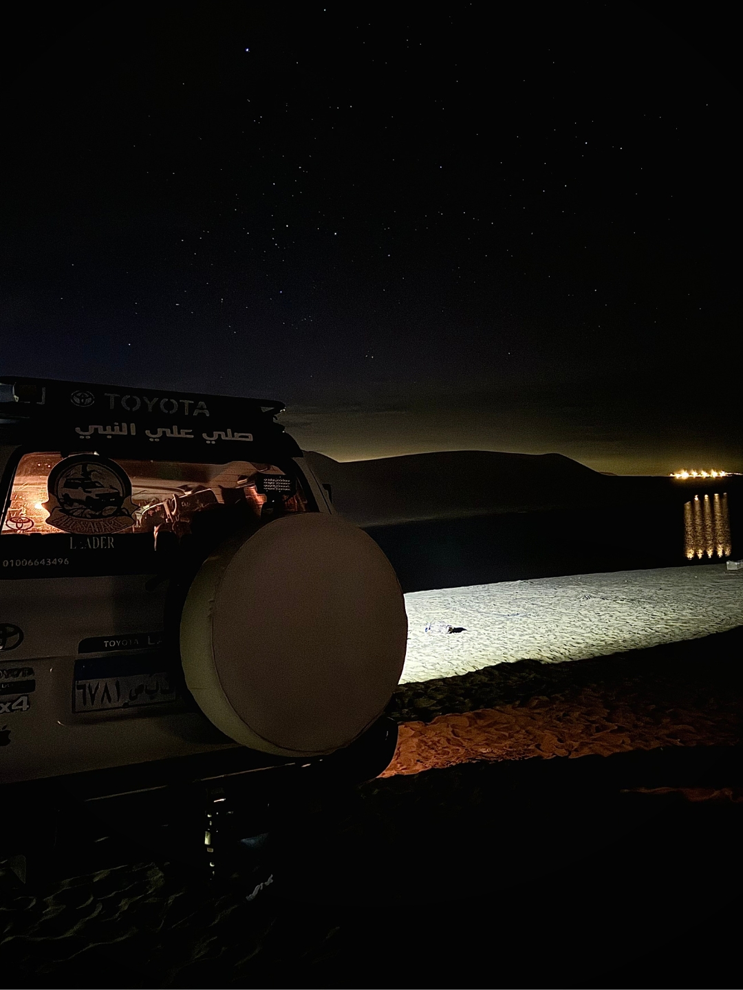 white 4x4 jeep standing in the desert at night under the stars 