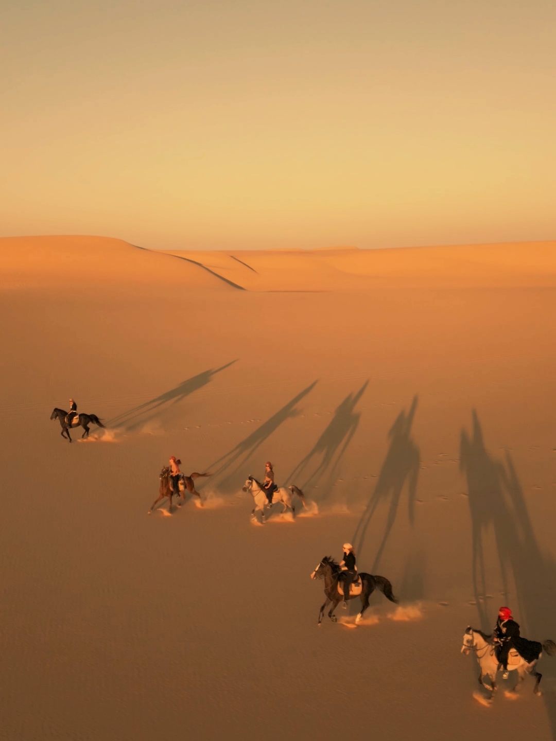 Drone shot of group horse riders in the desert in Fayoum, Egypt